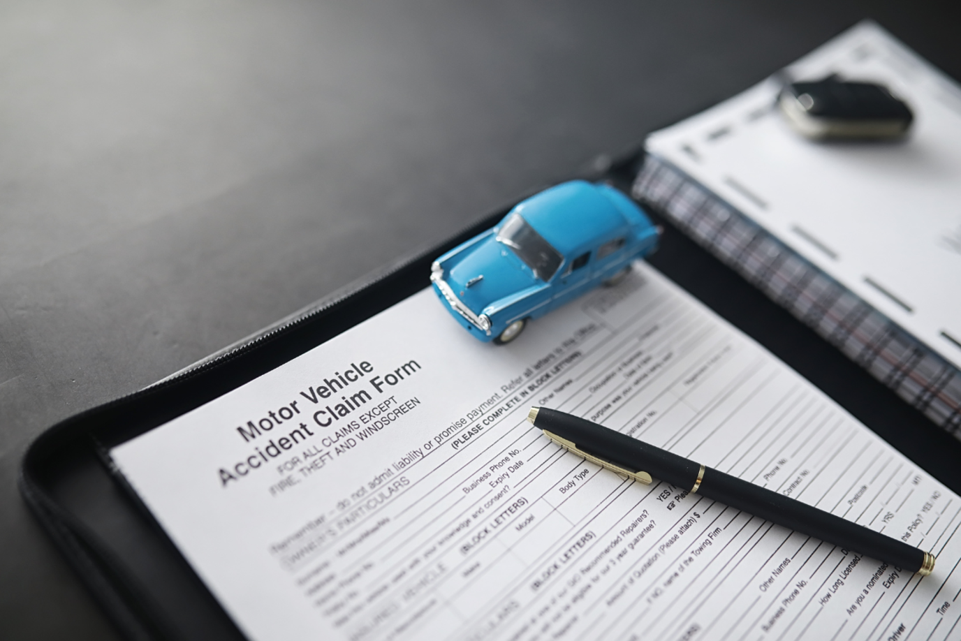 Closeup auf ein leeres Unfallformular für die Versicherung mit Stift auf dem Dokument