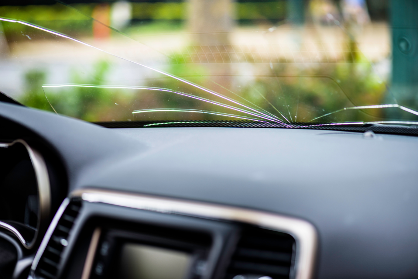 Close-Up einer kaputten Windschutzscheibe im Auto mit Rissen