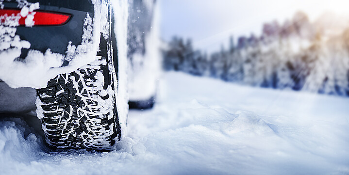 Die Winterreifen eines Autos sind mit Schnee bedeckt
