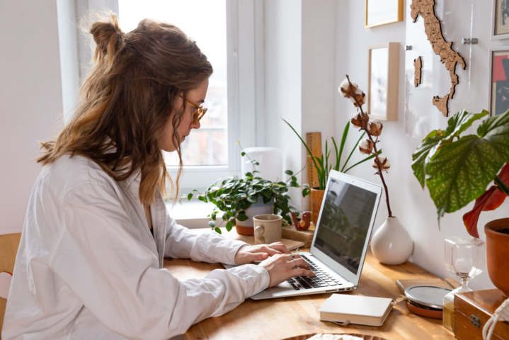 Frau sitzt nachdenklich am Laptop und tippt