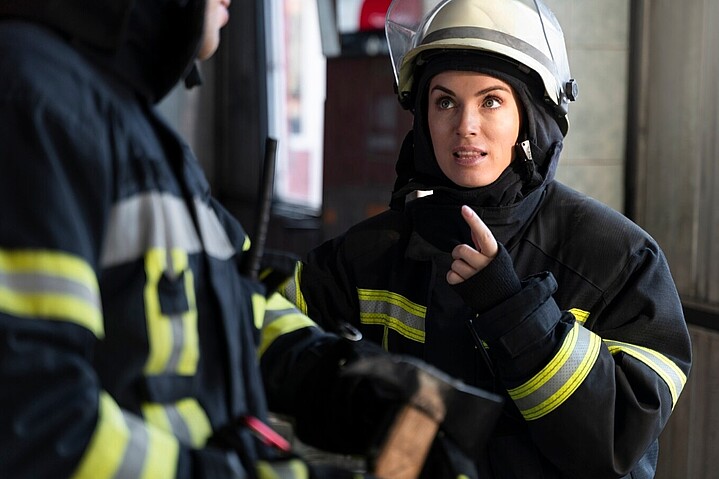 Feuerwehrfrau weist ihren Arbeitskollegen vor einem Einsatz an