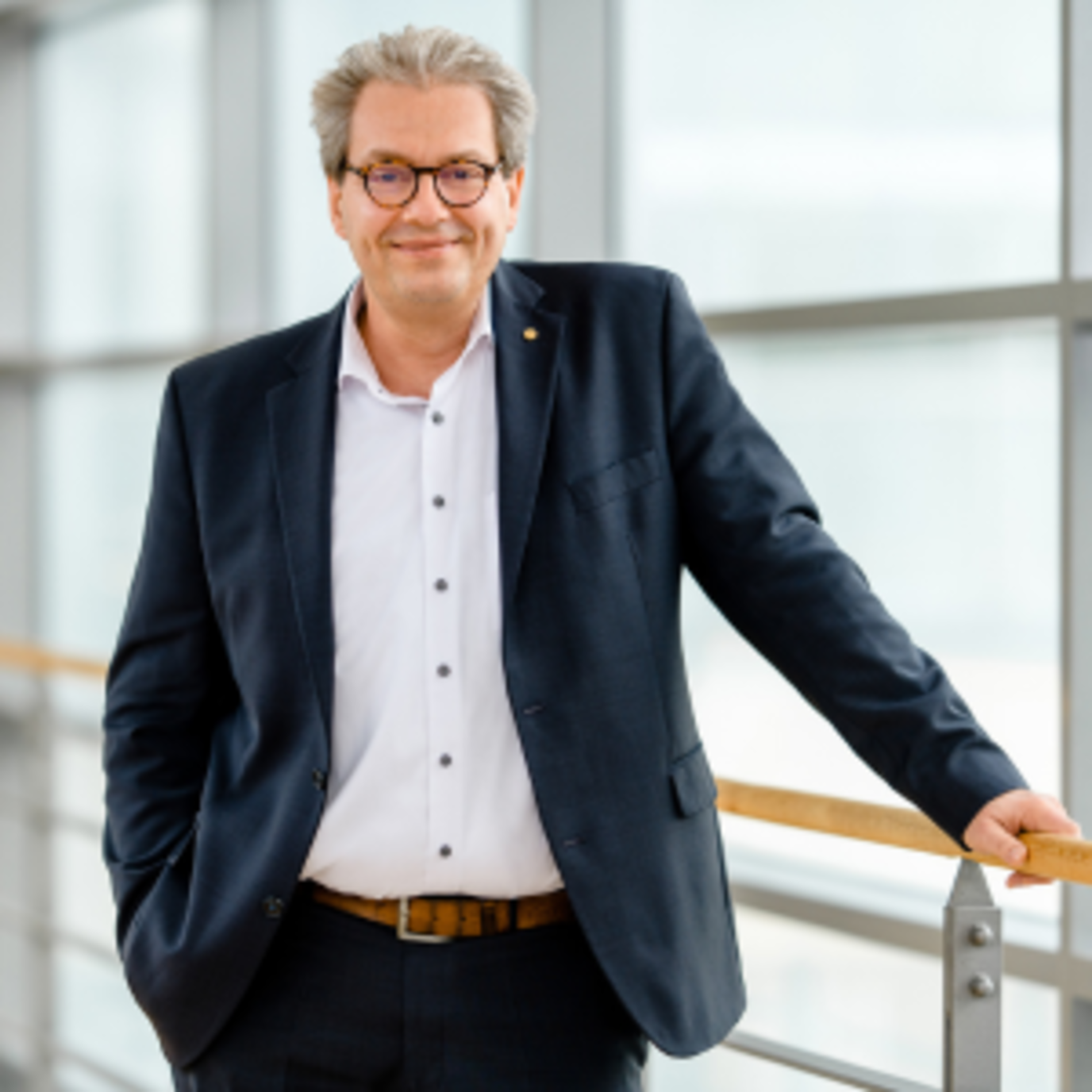 Portrait von Ralf Krause-Maier, Leiter des Kundenservice Direkt, im Anzug im Treppenhaus der GVV 