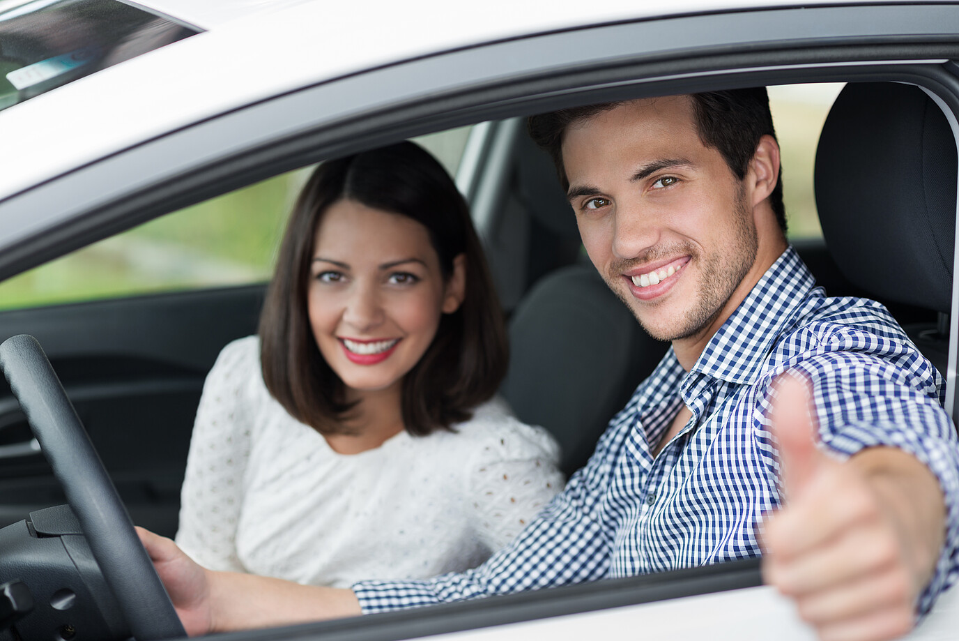 Ein Mann und eine Frau sitzen zufrieden im Auto
