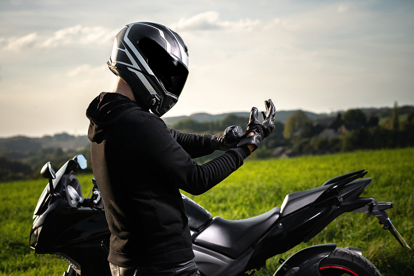 Ein Motorradfahrer zieht sich gerade seine Handschuhe an