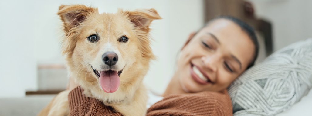 Eine junge Frau liegt auf dem Sofa mit ihrem Hund.