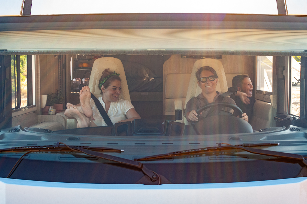 Gut gelaunte Familie mit Mutter, Vater und kleinem Sohn im Wohnmobil auf dem Weg in den Urlaub