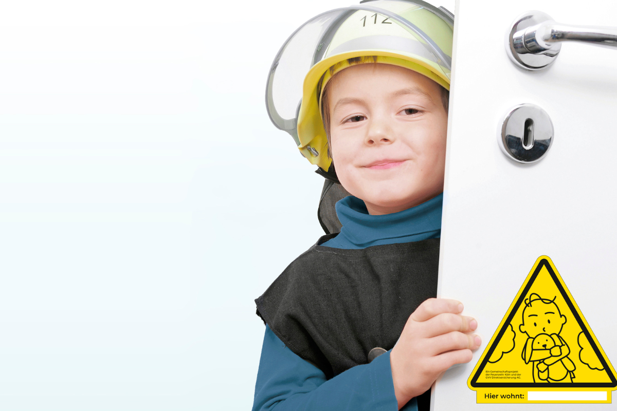 Junge schaut aus leicht geöffneter Tür hervor, auf der ein Kinderfinder-Aufkleber klebt